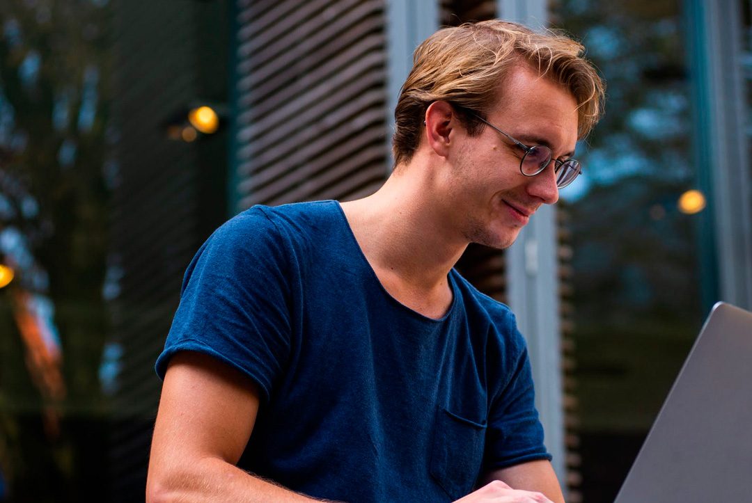 chico sonriendo con ordenador