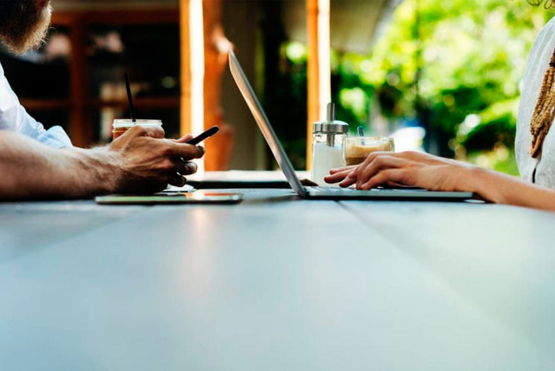 manos de persona con dispositivos digitales